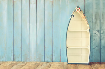 nautical boat shape shelves on wooden table. product display background, vintage filtered