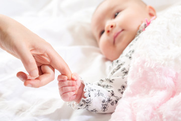 Wall Mural - Baby girl grasping her parents finger