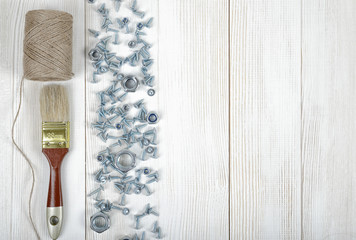 Wall Mural - Top view of screws, nuts, brush and twine on wooden DIY workbench with open space right side