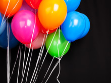 Group Of Colorful Balloons On Ribbons Over Black