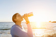 © Sergey Nivens - Woman drinking water on beach