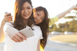 © Monet - Two Asian women are shooting themselves in the smart phone in the park