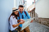 Fototapeta  - Happy couple on vacation sightseeing city with map