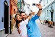 Happy couple taking selfie on the street during vacation in Euro