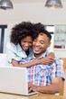 © WavebreakmediaMicro - Happy young couple using laptop in kitchen