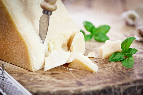 Fotografie, Obraz Parmesan Cheese with Basil Leaves on wooden board