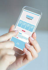 close up of hands with web design on smartphone