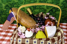 Picnic Basket With American Flag Fruit Cheese Bread Wine Cupcakes On Green Background