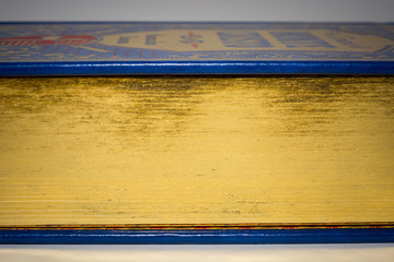 Gold edge of closed old vintage book with blue cover