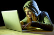 © Wordley Calvo Stock - young attractive teen woman wearing hood on hacking laptop computer cybercrime cyber crime concept
