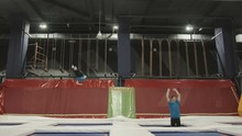 Three Professional Gymnasts Doing Trcks On Trampoline Synchrone. Amazing Tricks By Group Of Gymnasts.