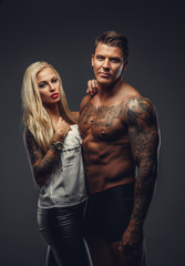 Poster - Modern tattooed couple posing in a studio.