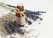Bottle of aroma lavender oil, empty parchment label, dried lavender flowers.
