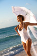© plprod - femme mariée souriant à la plage au bord de la mer avec une ombrelle