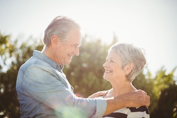 Wall Mural - Side view of cheerful senior couple looking at each other