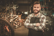 © Nejron Photo - Stylish bicycle mechanic standing in his workshop.