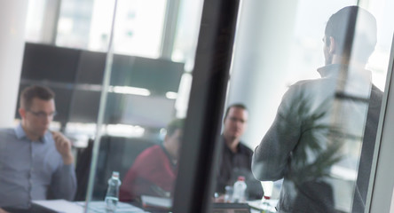 Businessman making a presentation at office. Business team leader delivering a presentation to his colleagues during meeting or in-house business training.