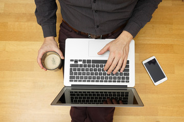 top view of young man chatting online with friends using laptop