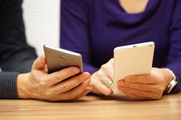 two young adults sharing music and files over mobile smart phone