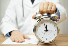 After Reading Diagnose, Doctor Is Showing Clock To Patient To Ma