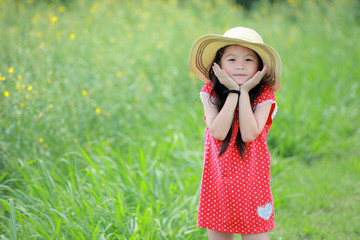 Wall Mural - Portrait of beautiful happy little girl in a field of yellow flower