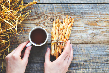 Wall Mural - Heap of bread sticks with tea on wooden table