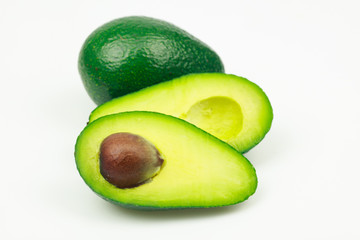 Wall Mural - Avocado fruit and one cut in half with seed, on white background.