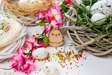 Beautiful Easter background with flowers and nest with eggs on white painted boards