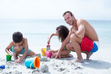 Happy father enjoying with children at beach 