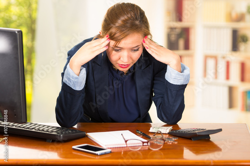 Business Woman Sitting By Desk Elbows On Table And Head Bent Over