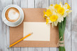  cup of coffee next to spring white flowers on wooden texture