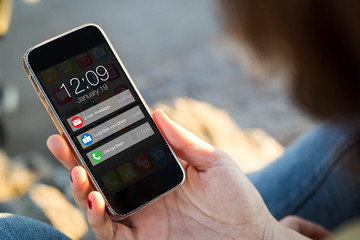 woman sitting in the street holding her smartphone showing  noti