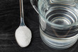 Spoon of salt, sugar, soda with glass of water