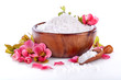 Sea bath salt in bowl and red blossom flowers on white background