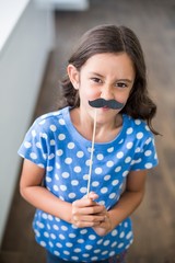 Wall Mural - Portrait of girl with artificial mustache 