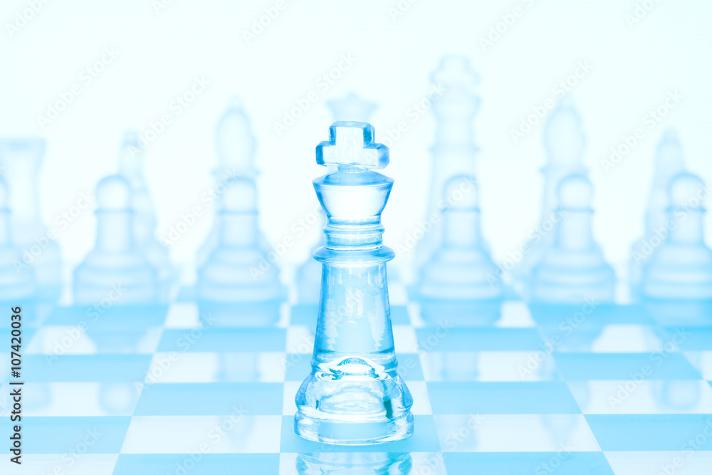Chess leader / Chess game concept of an icy frosted king standing in front  of chess pieces on glacial chessboard Fotografia, Obraz na Posters.sk