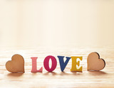 Hearts on wooden background with letters love