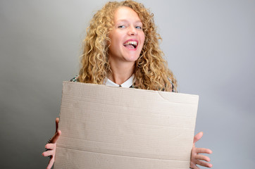 Happy girl holding blank board on grey background