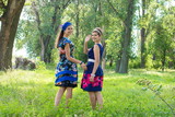 Fototapeta Las -  Two beautiful young woman relaxing outdoor. Two girls walking in park. two happy girls in the park for a walk, slight blur.
