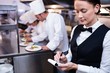 © WavebreakMediaMicro - Waitress with note pad in commercial kitchen