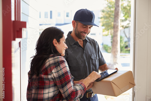 Stampe Woman Signing For Package From Courier At Home