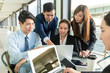 © leungchopan - Group of businesspeople working together at outdoor coffee shop