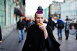 © raisondtre - beautiful young woman eating a hot dog on the way to the street