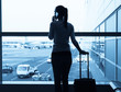 © kieferpix - Young woman using her phone at the airport.
