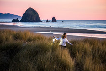 Caucasian Woman Carrying Lantern On Cannon Beach, Oregon, United States