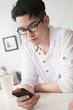 © JGI/Tom Grill/Blend Images - Mixed race man texting on cell phone
