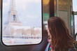© Song_about_summer - tourist looking to the Eiffel Tower through the window of metro in Paris, smiling girl visiting France