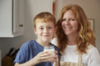 © Jeff Greenough/Blend Images - Caucasian mother and son drinking milk in kitchen