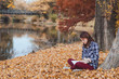 reading concept, young woman with book in autumn park