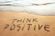 think positive, concept written on the sand